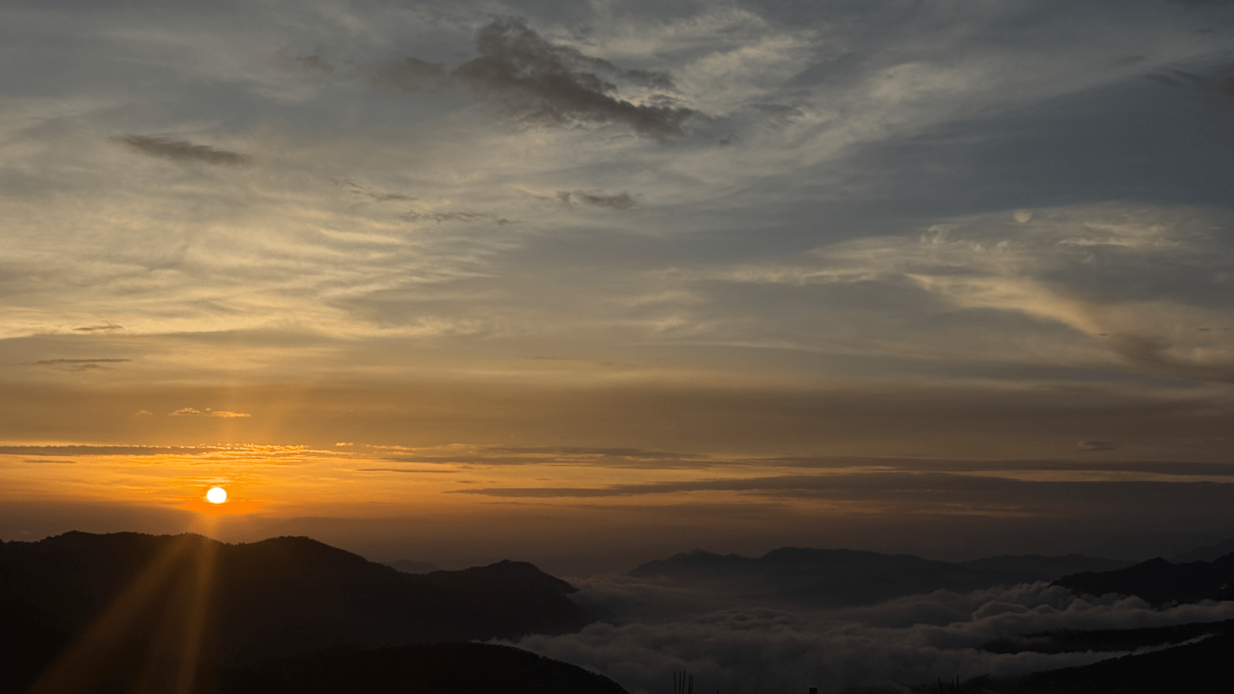 The Pinewood Homestay Kufri, a multi-storey hill house on a forested slope, at sunset